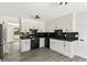 Bright kitchen with white cabinets, black appliances and countertops, and stylish light fixture at 8649 Cedar Creek Rdg, Riverdale, GA 30274