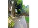 Backyard with paved patio, stone pathway leading to a garden, wooden fence and lush greenery at 227 Bennett Farms Trl, Acworth, GA 30102