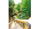 A well-maintained garden with a greenhouse and landscaping viewed from stairs of outdoor deck at 227 Bennett Farms Trl, Acworth, GA 30102