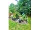 Garden area with fenced border featuring a variety of container plants, small trees and a greenhouse at 227 Bennett Farms Trl, Acworth, GA 30102
