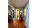 Hallway featuring hardwood floors, mirrors, and doorways leading to the bathroom and bedrooms at 227 Bennett Farms Trl, Acworth, GA 30102