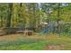 Spacious backyard featuring a trampoline and swing set, surrounded by lush greenery and a wooden fence at 2653 Partridge Trl, Duluth, GA 30097