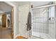 Clean bathroom featuring a glass enclosed shower and door leading to a bedroom with carpeted floors at 2653 Partridge Trl, Duluth, GA 30097