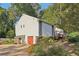 Side view of home showing an attached garage with a red door and established landscaping at 2653 Partridge Trl, Duluth, GA 30097