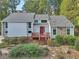 Charming home with a stone facade, red door, wood porch and a beautifully landscaped front yard at 2653 Partridge Trl, Duluth, GA 30097