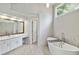 Bright bathroom featuring a soaking tub, wood-framed mirror and white marble accents at 4062 Brookside Pkwy, Decatur, GA 30034