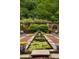 Relaxing backyard featuring a long pond, lush greenery, and decorative stone walls at 114 Lees Lake Rd, Fayetteville, GA 30214
