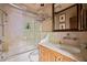 Bathroom with tile shower over tub, marble countertop vanity, and wood framed mirror at 114 Lees Lake Rd, Fayetteville, GA 30214