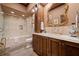 Bathroom featuring a bathtub, marble vanity with gold-framed mirror, and traditional design at 114 Lees Lake Rd, Fayetteville, GA 30214