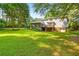 Expansive backyard with lush lawn, mature trees, and a screened-in porch and deck at 207 Lees Lake Rd, Fayetteville, GA 30214