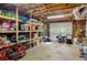 Spacious unfinished basement with exposed ceiling and shelving for ample storage; garage door entrance at 207 Lees Lake Rd, Fayetteville, GA 30214