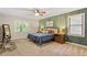 Bright bedroom featuring a bed with a blue cover, green accent wall, and side tables with lamps at 207 Lees Lake Rd, Fayetteville, GA 30214