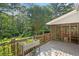 Wood deck showcasing mature trees, lush greenery, and adjacent screened porch at 207 Lees Lake Rd, Fayetteville, GA 30214
