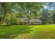 Lovely home featuring a covered front porch with rocking chairs and mature trees at 207 Lees Lake Rd, Fayetteville, GA 30214