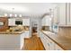 Spacious kitchen featuring white cabinets, tan countertops, stainless steel appliances, and hardwood floors at 207 Lees Lake Rd, Fayetteville, GA 30214