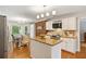 Eat-in kitchen featuring white cabinets, an island, stainless steel appliances, and a brick wall at 207 Lees Lake Rd, Fayetteville, GA 30214