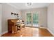 Bright living area with a piano, hardwood floors, and double doors to the outside at 207 Lees Lake Rd, Fayetteville, GA 30214