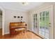 Bright living area with a piano, hardwood floors, and double doors to the outside at 207 Lees Lake Rd, Fayetteville, GA 30214