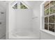 Bathroom featuring a soaking tub with marble trim and a window bringing in natural light at 2688 Beddington Way, Suwanee, GA 30024