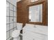 Modern bathroom featuring a glass-enclosed shower, wood accent wall and a white vanity with a large mirror at 2688 Beddington Way, Suwanee, GA 30024