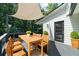 Wood deck with sun shade, wood table and chairs, plants, and wooded backyard at 2688 Beddington Way, Suwanee, GA 30024