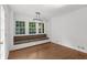 Bright dining area features a window seat, hardwood floors, and a modern light fixture at 2688 Beddington Way, Suwanee, GA 30024