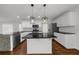Modern kitchen features stainless steel appliances, sleek black countertops and island with unique pendant lights at 2688 Beddington Way, Suwanee, GA 30024