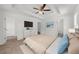 Well-lit main bedroom featuring a tray ceiling, ceiling fan, TV, and ensuite bathroom access at 2688 Beddington Way, Suwanee, GA 30024