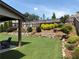 Lush backyard features a manicured lawn, terraced landscaping, and seating areas at 4745 Belcrest Way, Cumming, GA 30040