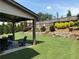 Serene backyard featuring a covered patio and expertly manicured lawn with landscaping at 4745 Belcrest Way, Cumming, GA 30040