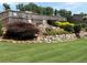 Picturesque backyard with lush green lawn, stone accents, and a decorative garden at 4745 Belcrest Way, Cumming, GA 30040