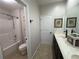 Clean bathroom featuring a shower, toilet, double vanity, and neutral tile flooring at 4745 Belcrest Way, Cumming, GA 30040
