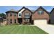 Beautiful brick home featuring manicured lawn and mature landscaping at 4745 Belcrest Way, Cumming, GA 30040
