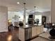 Open-concept layout with kitchen island overlooking the living room with stone fireplace at 4745 Belcrest Way, Cumming, GA 30040