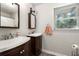 Cozy bathroom features a dual sink vanity, mirror, and natural light from the window at 1328 Hidden Hills Pkwy, Stone Mountain, GA 30088