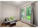 Bedroom with neutral tones, large window with green view, love seat, and carpet at 1328 Hidden Hills Pkwy, Stone Mountain, GA 30088
