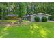 Charming ranch-style home with stone accent and mature trees, situated on a lush green lawn at 1328 Hidden Hills Pkwy, Stone Mountain, GA 30088