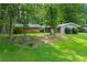 Ranch home featuring natural landscaping, mature shade trees, and a sprawling green lawn at 1328 Hidden Hills Pkwy, Stone Mountain, GA 30088