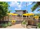 Outdoor seating area with yellow umbrellas, lush greenery, and a wooden fence and planters at 300 Brickworks Ne Cir # 302, Atlanta, GA 30307