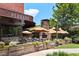 Outdoor dining area at Plancha Restaurant with umbrellas, greenery, and a brick fireplace at 300 Brickworks Ne Cir # 302, Atlanta, GA 30307