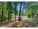 Large backyard surrounded by mature trees and fencing, offering privacy and outdoor space at 830 The Cir, Lawrenceville, GA 30043