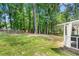 Expansive backyard with lush greenery, a charming white fence and a glimpse of the covered deck at 830 The Cir, Lawrenceville, GA 30043