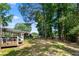 Spacious backyard with mature trees, lush lawn, and a covered deck area perfect for outdoor gatherings at 830 The Cir, Lawrenceville, GA 30043