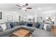 Open-concept living room boasts a spacious gray sofa, connecting to a modern kitchen with white cabinets at 830 The Cir, Lawrenceville, GA 30043