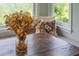 Close-up of breakfast nook table styled with flowers and pillows near a window at 9 Saint Claire Ne Ln, Atlanta, GA 30324