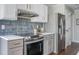 Contemporary kitchen boasts stainless steel appliances, white cabinets, and wood flooring at 9 Saint Claire Ne Ln, Atlanta, GA 30324