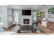 Bright living room showcasing a fireplace, large TV, hardwood floors, and natural light at 9 Saint Claire Ne Ln, Atlanta, GA 30324