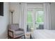 Bright bedroom with a chair and balcony access that offers views of the greenery outside at 9 Saint Claire Ne Ln, Atlanta, GA 30324