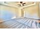 Large bedroom with a tray ceiling, ceiling fan, neutral paint, and plush carpeting at 12 Confederate Nw St, Cartersville, GA 30121