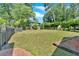 Spacious, grassy backyard bordered by mature trees and wooden retaining wall provides a private outdoor oasis at 1406 Arden Sw Dr, Marietta, GA 30008